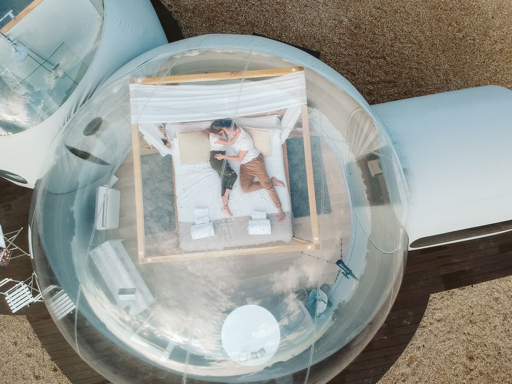 Passionate couple on bed in bubble hotel