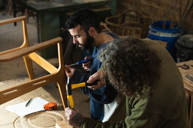 Male artisans creating wooden furniture in workshop