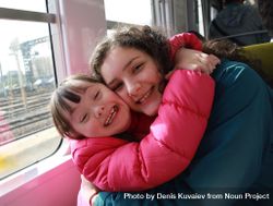 Two sisters embrace on the train 5XpqG5