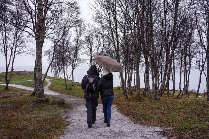 Friends walking on park path near sea