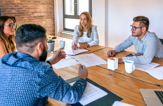 Businesspeople in a meeting looking at construction drawings
