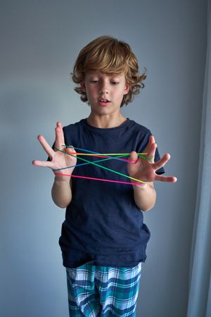 Boy looking at rainbow finger rope