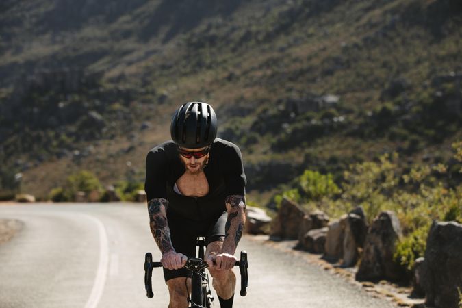 Athlete riding a bicycle uphill on mountain road