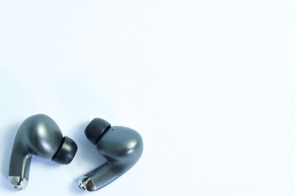 Top view of wireless earbuds on plain table with copy space