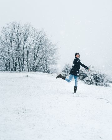 Woman playing with snow on winter field