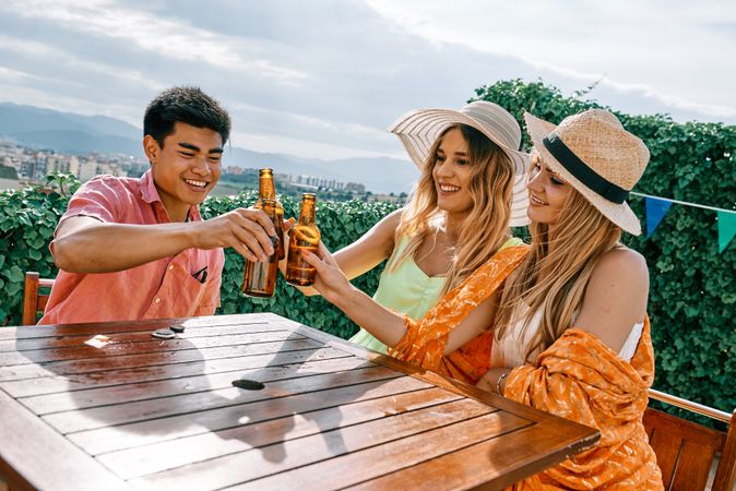 a group of young people having a good time in a summer day and cheering with beer
