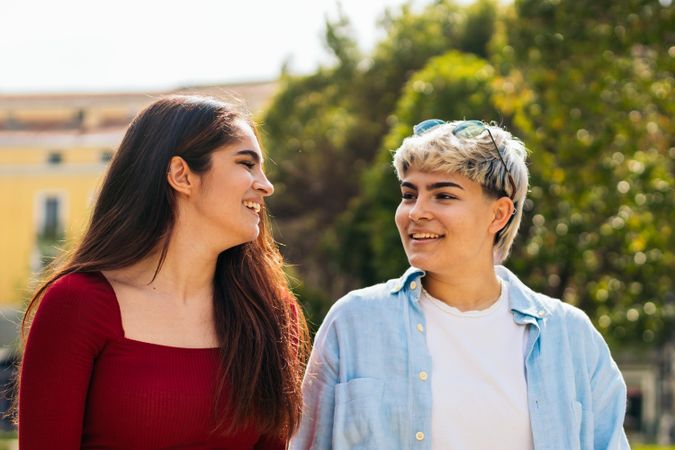 two women walking and looking each other in a park