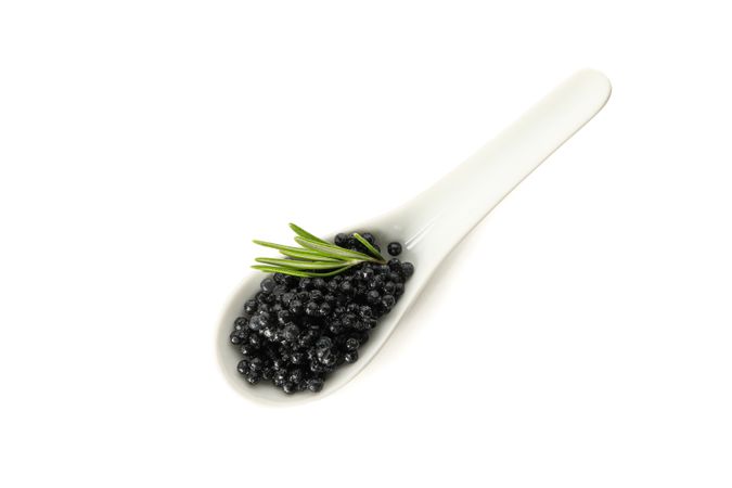 Glass spoon with caviar isolated on blank background