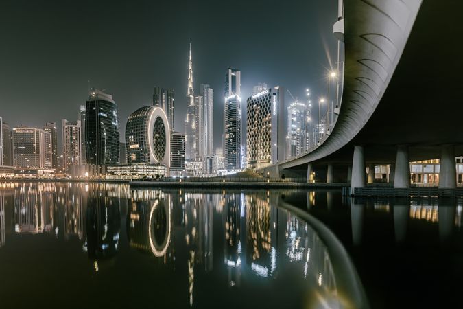 Dubai skyline across body of water during night time showcasing the tallest building Burj khalifa