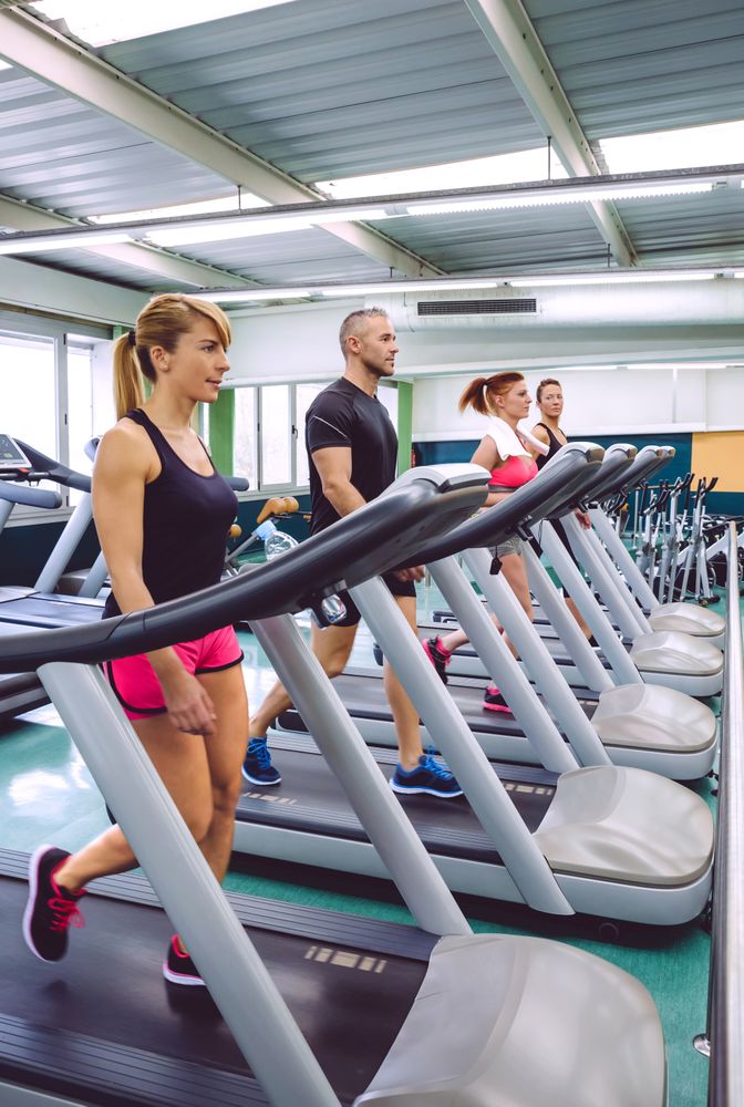 Group of fit people on treadmills in gym