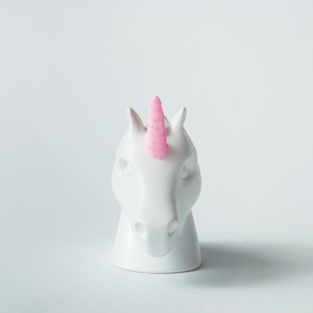 Painted unicorn head with pink horn on bright background