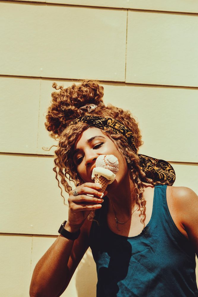 Black female enjoying an ice cream cone in the sun