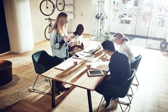 Woman standing and reviewing data on documents with colleagues