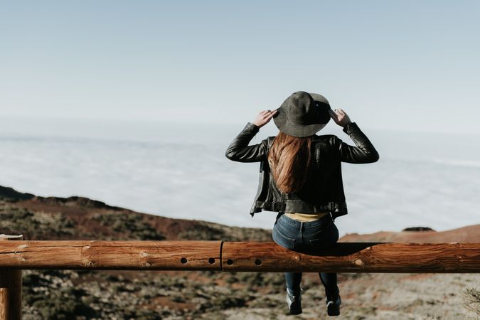 Woman on fence on hill