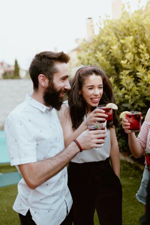 Group of cheerful friends clinking glasses at party