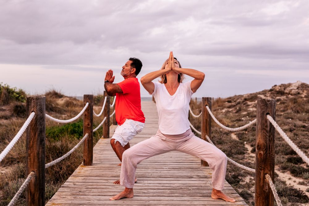 Adult couple meditating on wooden path
