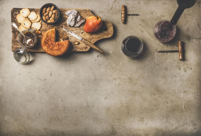 Cheese plate with glasses of red wine being poured, with copy space