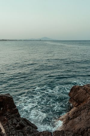 Sea waves hitting rocky cliff