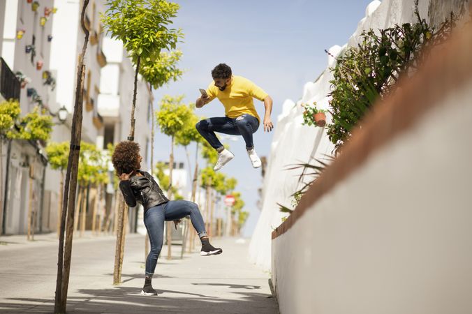 Man jumping and making photo of girlfriend