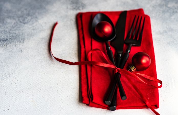 Christmas cutlery wrapped in red napkin and baubles