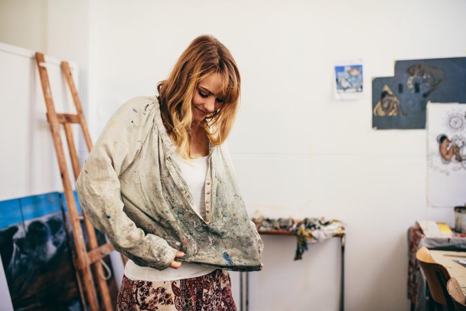 Young woman in painter smock in art studio