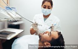 Male patient getting teeth cleaned in clinic 4BkYdb
