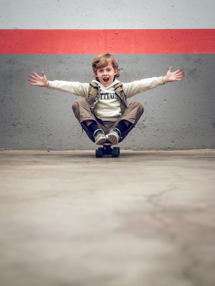 Funny child sitting on skateboard