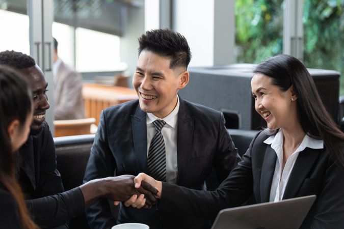 Diverse group of business people smiling and shaking hands