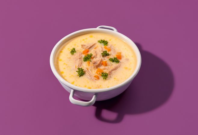 Greek chicken soup with lemon juice, minimalist on a purple background