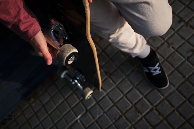 Crop skater resting on pavement