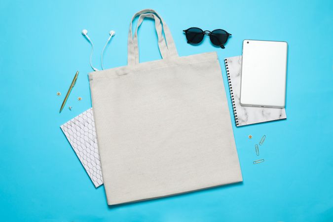 Eco bag, tablet, stationery and glasses on color background, space for text