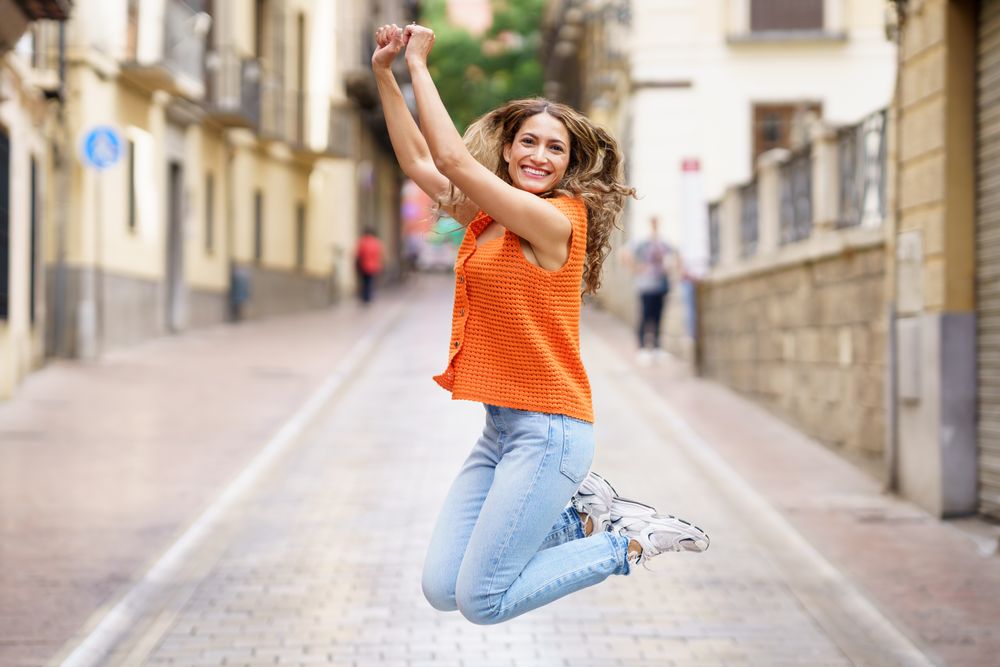 Woman jumping for joy on street