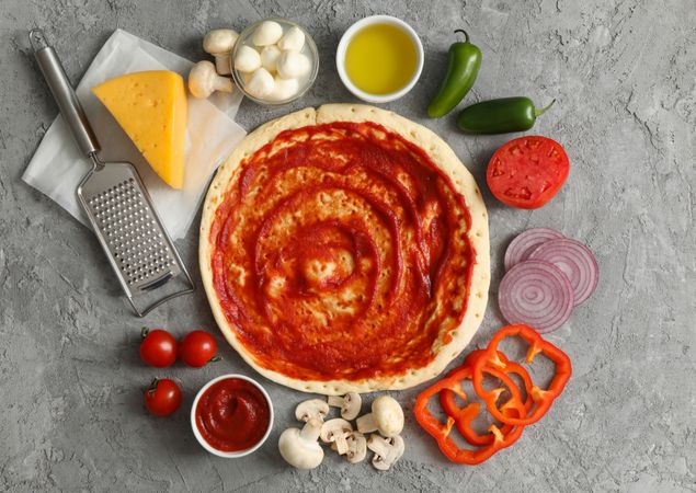 Concept for cooking pizza with ingredients on gray table