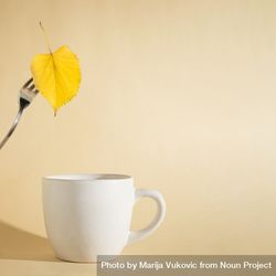 Autumn yellow leaf on a fork above a cup 4mr6Xb