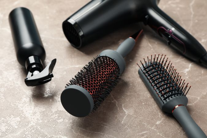 Composition with hairdresser accessories on gray background, close up