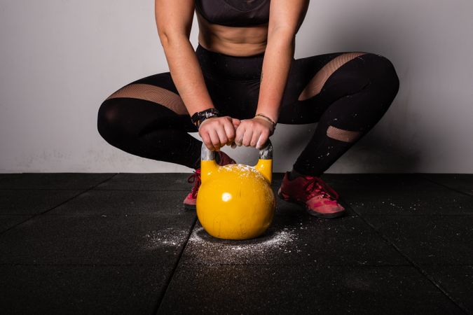 woman lifting kettlebell in gym