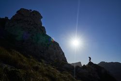 Unrecognizable traveler standing on hill in mountains