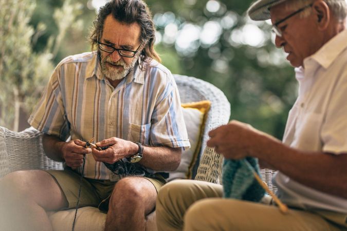 Two older men learning  to knit