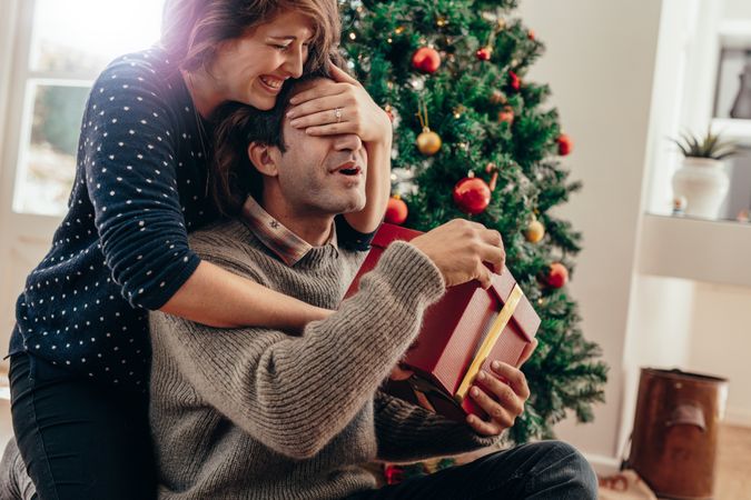 Young couple having fun celebrating Christmas with presents