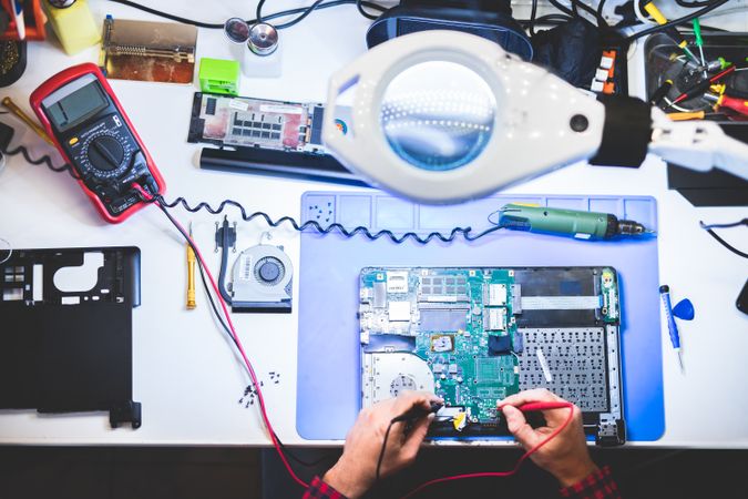 Man repairing laptop at workplace