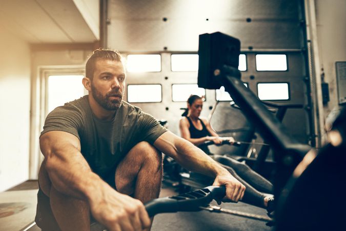Focused man on rowing machine in gym