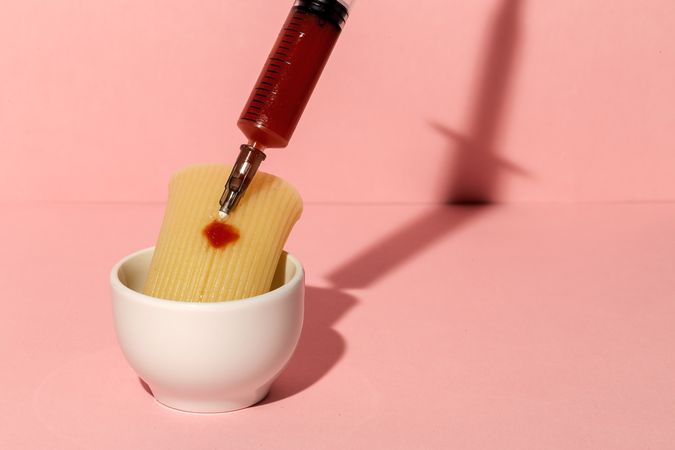 Stuffed pasta with red sauce in syringe