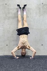 Man doing handstand in gym