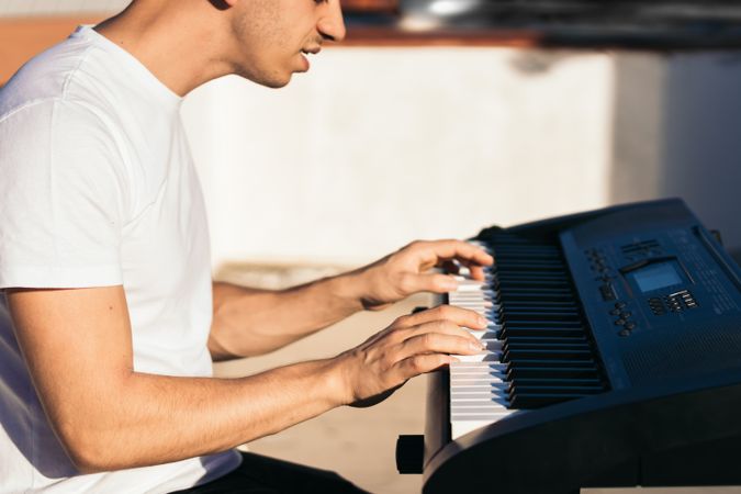 man playing piano on an urban rooftop