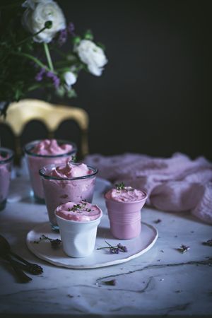 tasty glasses of strawberry mousse on a table with flowers