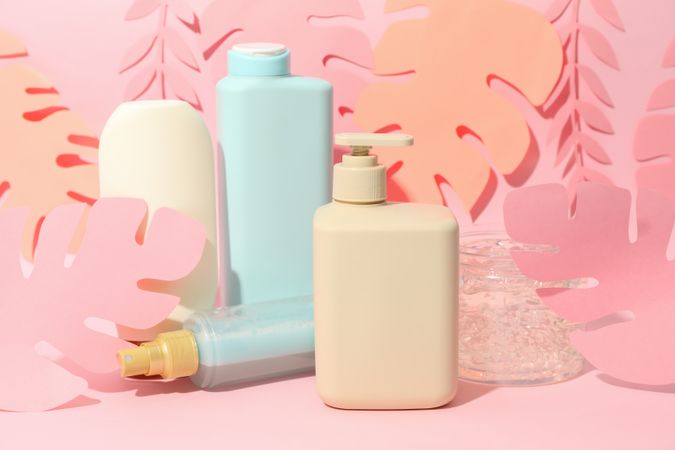 Composition with hairdressing accessories and paper palm leaves on pink background