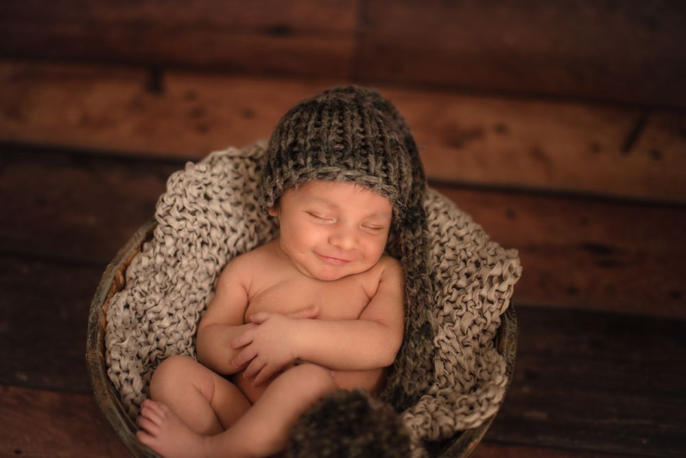 Naked baby sleeping in bucket
