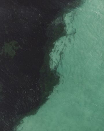 Aerial shot of where shallow sea meets dark trench