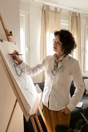 Person drawing city on canvas