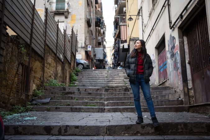 woman standing on steps on shabby street